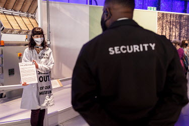 A security guard approaches a scientist chained to a display at the 'Our Future Planet' exhibition at the Science Museum in South Kensington. The scientists are protesting Shell's sponsoring of the ex...
