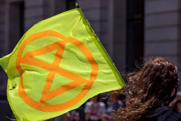 A woman carries an Extinction Rebellion flag during a protest by scientists against Shell's sponsorship of 'Our Future Planet', an exhibition advocating techno-fixes for the climate crisis, at The Sci...
