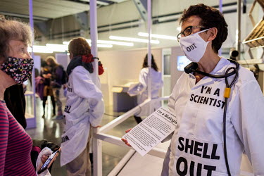 A visitor talks with a scientist chained to a display at the 'Our Future Planet' exhibition at the Science Museum in South Kensington. The scientists are protesting Shell's sponsoring of the exhibitio...