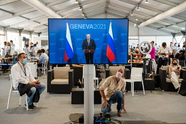 Members of the world's press gathered in the media centre watch a television broadcast of Vladimir Putin speaking at the Joe Biden/Vladimir Putin summit meeting which was taking place at nearby Villa...