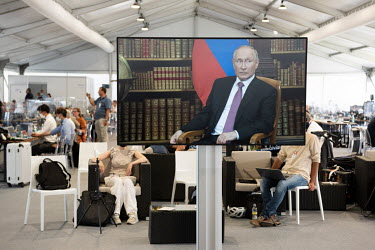 Members of the world's press watch a television broadcast from the media centre set up at the Joe Biden/Vladimir Putin summit meeting which was taking place at nearby Villa La Grange.