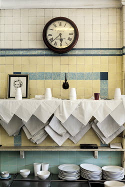 An antique clock, plates and paper bags on the wall of F Cooke's Pie and Mash shop in Broadway Market, Hackney.