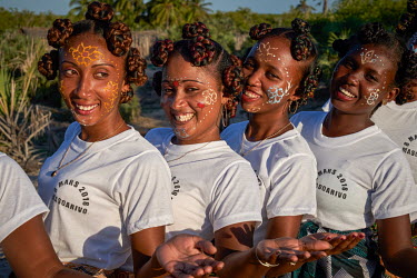 Women with painted faces perform a dance in Beanjavilo, a village set among mangroves in the western coastal region.