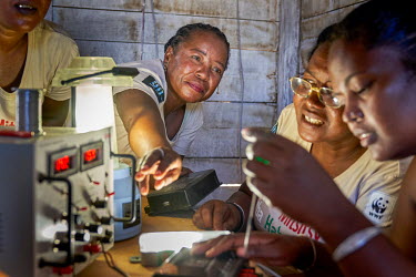 'Solar Mamas' repairing solar lights in Ambakivao, a village set among mangroves in the western coastal region.  Dubbed the 'Solar Mamas', these women were the first in their village to join a program...