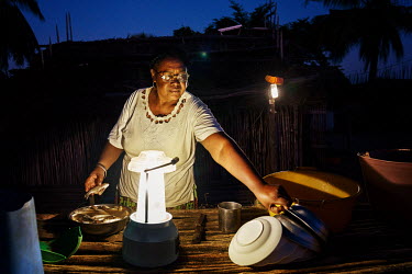 'Solar Mama' Yollande Randrianambinina cooks fish by the light of a solar lamp. â�� Dubbed the 'Solar Mamas', these women were the first in their village to join a program established by the World Wi...