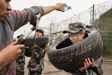 Nai Nai (right), a 23-year-old live-streamer, has water poured over her head during filming at a military boot camp for a broadcasting program. Nai Nai's fans are mostly Chinese men between 15 and 30...