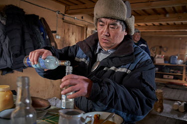 Kim Pomishin, a shaman at a Buryati village in Selenga on the shore of Lake Baikal, uses vodka to prepare for a ritual.   Crowned the 'Jewel of Siberia', Lake Baikal is the world's deepest lake, and t...