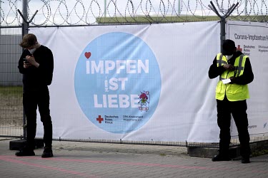 A banner reads: 'Vaccinate Is Love' (mpfen Ist Liebe), to promote the COVID-19 vaccination centre at the Impfzentrum Tegel at the Former Tegel Airport.
