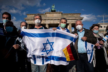 Protestors with the flag of Israel during a rally of the German Jewish community and political parties in front of the Brandenburger Gate in solidarity with Israel and against anti-semitism and racism...
