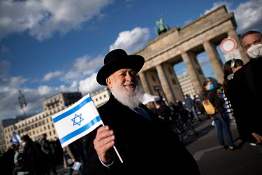 Rabbi Yitzhak Ehrenberg displays the flag of Israel during a rally of the German Jewish community and political parties in front of the Brandenburger Gate in solidarity with Israel and against anti-se...