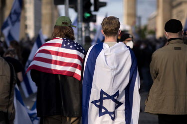 Protestora with the flag of Israel and the USA draped around their shoulders during a rally of the German Jewish community and political parties in front of the Brandenburger Gate in solidarity with I...