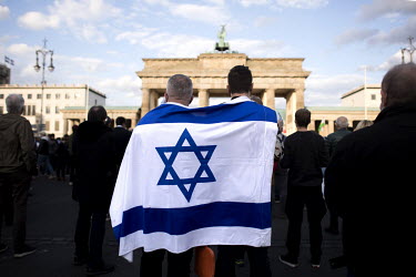 A protestor with the flag of Israel draped around their shoulders during a rally of the German Jewish community and political parties in front of the Brandenburger Gate in solidarity with Israel and a...