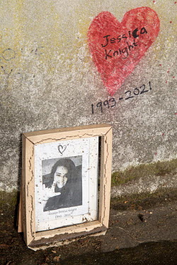 A photograph left in tribute to a young woman who died at the age of 28 at the National Covid Memorial Wall on London's South Bank.   More than 1000 volunteers painted the 150,000 hearts on the wall t...