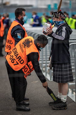 Security staff scan Scotland fans and check inside their sporrans (a small bag around the waist and part of the traditional kilt) as they enter Hampden Stadium where Scotland played the Czech Republic...