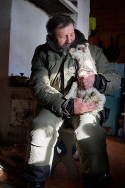 A forestry department ranger, working in the area around Lake Baikal, with a goat.  Crowned the 'Jewel of Siberia', Lake Baikal is the world's deepest lake, and the biggest lake by volume, holding 20%...