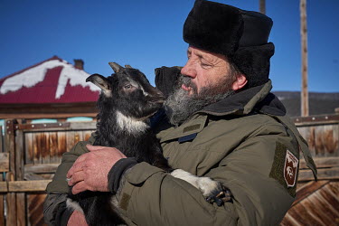 A forestry department ranger, working in the area around Lake Baikal, with a goat.  Crowned the 'Jewel of Siberia', Lake Baikal is the world's deepest lake, and the biggest lake by volume, holding 20%...