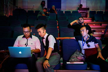Uighur pop sensation Ablajan (2nd from left) checks a video on a laptop during rehearsals for a planned live webcast concert scheduled for that afternoon. However, the performance, to be held at a sta...
