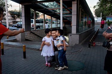 A fan photographs Uighur pop sensation Ablajan as he gets a kiss from her young relatives. Earlier a planned live webcast concert scheduled for that afternoon had been cancelled. The performance, to b...