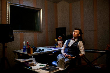 Uighur pop sensation Ablajan (right) appears disappointed and frustrated as he sits in his studio following the cancellation of a planned live webcast concert scheduled for earlier that afternoon. The...
