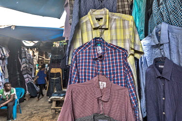 Second-hand shirts, many with the retailer's labels and the price labels of the United Kingdom charity shops they were once on sale in still attached, on stall in Kantamanto market, West Africa's larg...