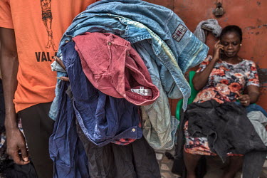 At a retailer's stall in Kantamanto's second-hand clothing market, Boison Kwamena (foreground), a fashion enthusiast and founder of The Revival an up-cycling outfit in Accra, collects discarded poor q...