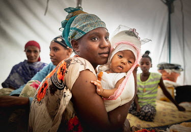Hiwot (left) with her baby Tarikua (six months) in a camp for internally displaced people. Tarikua was born in the local hospital that was one of the many buildings destroyed following an armed attack...