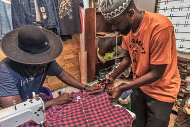Yayra Agbofah (left), a creative social entrepreneur, and Boison Kwamena (right), a fashion enthusiast, co-founders of The Revival an up-cycling outfit in Accra, work with discarded poor quality secon...