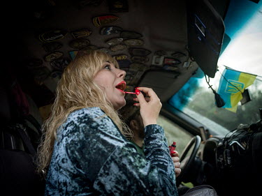 Natalia Voronkova, a volunteer who offers support and basic first aid training for Ukrainian government forces fighting Russian-backed separatists in the east of the country, puts on lipstick in the c...