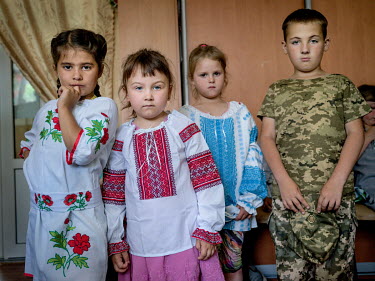 Darina Korol (6), Asya Malik (5) and Alina Alexeeva (6) wearing donated traditional Ukrainian folk costumes, while Yaroslav Koukoul (9) wears his own military-style outfit.  Natalia Voronkova (not pic...