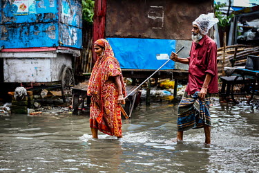 A couple make their way along a flooded road.  Water is essential for survival, yet in Bangladesh water also has the power to destroy anything in its path. For months at a time, monsoon season brings...
