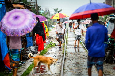 People walk through the rain sheltering beneath their umbrellas.  Water is essential for survival, yet in Bangladesh water also has the power to destroy anything in its path. For months at a time, mon...