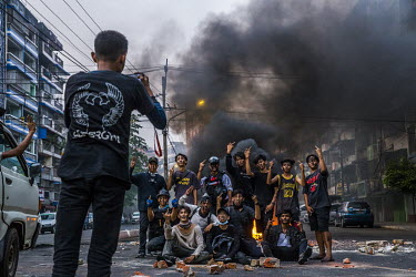 A group of young protestors take a picture after buring tires and setting road blocks on the main road while security forces clear other road blocks they previous erected in their neighbourhood, in Ta...