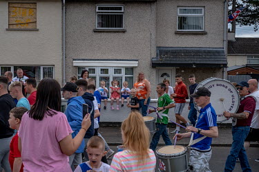 Crowds gather to watch a marching band practise for the Orangemen's Day parade in Ballycraigy.