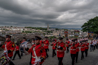 A Loyalist Orange parade along the walls of the City of Derry/Londonderry. In the background the Catholic Bogside area.