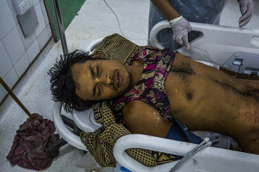 A man with a gunshot wound waits to get treated inside an emergency ward at a hospital where medical doctors and volunteer medics discreetly treat injured protestors and civilians.