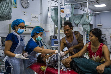 Accompanied by his mother, a friend and volunteer medics, injured protestor, Hein Htet Aung (22), who has wounds to the face believed to be from a gunshot fired by soldiers who raided his neighbourhoo...