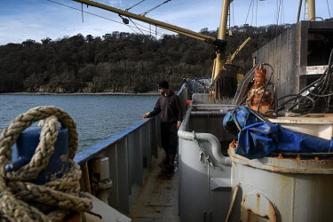 Crewmember Steve Bennet watches as nets are cast into the sea from the trawler of mussel producing company Deepdock Ltd as the boat heads out into the Menai Strait to collect mussels which the company...