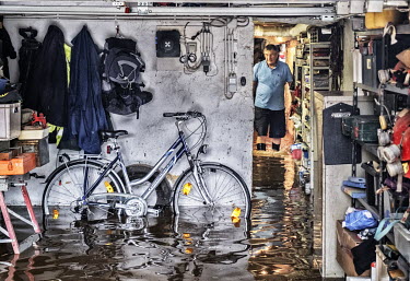 A man stands calf deep in water that has flooded his basement. Heavy rain caused the River Lomme to burst its banks resulting in widespread flooding in the provinces of Namur and Luxembourg and Liege.