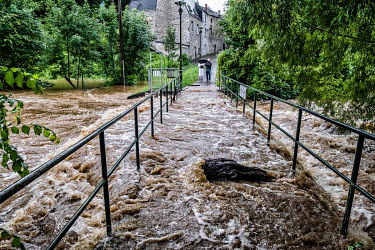 A couple look at the the River Lomme after heavy rain caused its banks to burst resulting in widespread flooding in the provinces of Namur and Luxembourg and Liege.