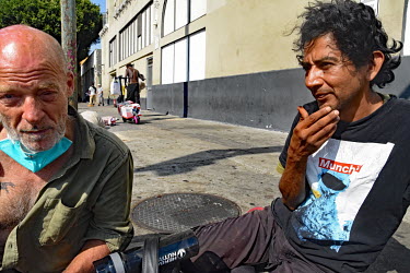 Scotty (left), a homeless crystal meth addict sits on the pavement on San Pedro street.  Thousands of homeless people camp out in the centre of Los Angeles, in an area of about 50 blocks. In greater L...