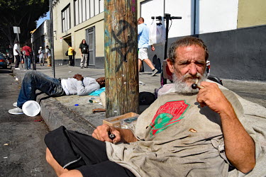 A homeless crystal meth addict sits on the pavement.  Thousands of homeless people camp out in the centre of Los Angeles, in an area of about 50 blocks. In greater Los Angeles, there are 70,000 homele...