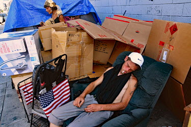 Rodney, a heroin user, sleeping in an arm chair surrounded by cardboard boxes.  Thousands of homeless people camp out in the centre of Los Angeles, in an area of about 50 blocks. In greater Los Angele...