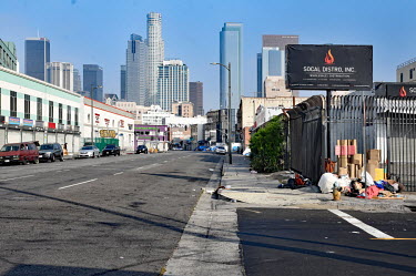 City centre skyscrapers loom over a street lined with homeless people's shelters.  Thousands of homeless people camp out in the centre of Los Angeles, in an area of about 50 blocks. In greater Los An...