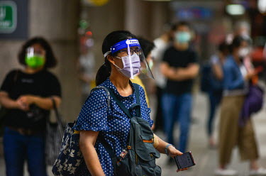 A woman wearing a face mask and a visor while travelling on the Taipei MRT system during 'Level 3' period of heightened alertness due to a recent rise in COVID-19 cases in Taiwan, mostly occuring in t...