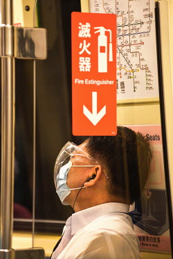 A man wearing a face mask and a visor while travelling on the Taipei MRT system during 'Level 3' period of heightened alertness due to a recent rise in COVID-19 cases in Taiwan, mostly occuring in the...