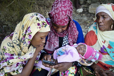Different generations of women look at a message on a mobile phone.