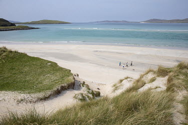 A family and dog walking on Seilebost Beach, one of several on the Isle of Harris which is famous for white sands, clear water and much smaller numbers of visitors compared to more easily accessible s...