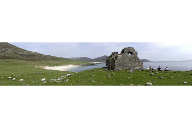 Walkers having lunch by a ruined crofter's house with sheep hanging out.  The Isle of Harris is one of the more remote destinations in Scotland and the U.K., requiring multiple ferry rides and a very...
