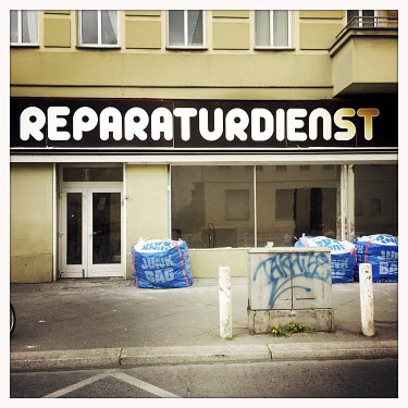 The facade of a closed shop called Reparaturdienst in Moabit.  The Berlin district of Moabit is an artificial island completely surrounded by water that was once home to various industries and staunch...