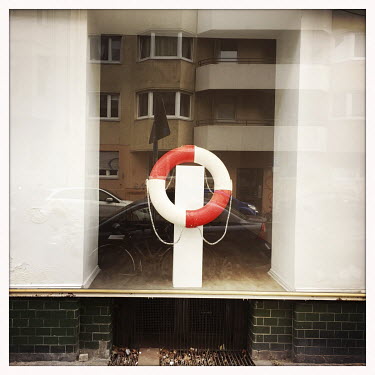 A closed gallery with a lifebuoy ring displayed in its window.  The Berlin district of Moabit is an artificial island completely surrounded by water that was once home to various industries and staunc...